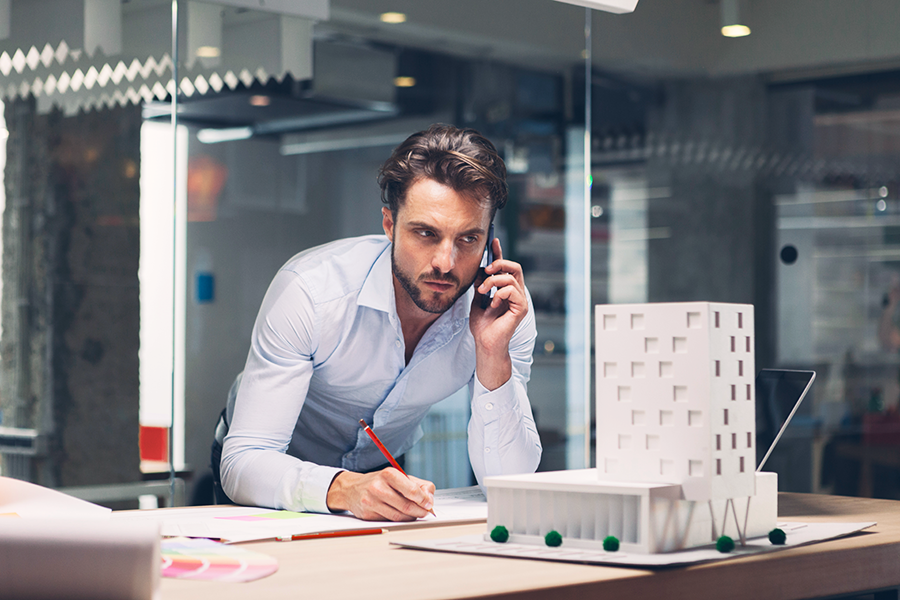 Designer talking on smart phone in office.
